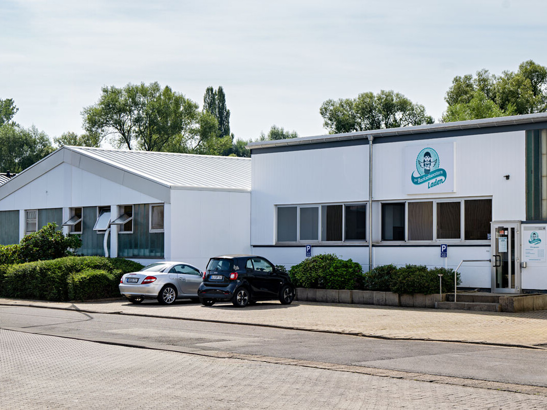 Modern daycare center building exterior with parking area and signage in Ladens, Germany