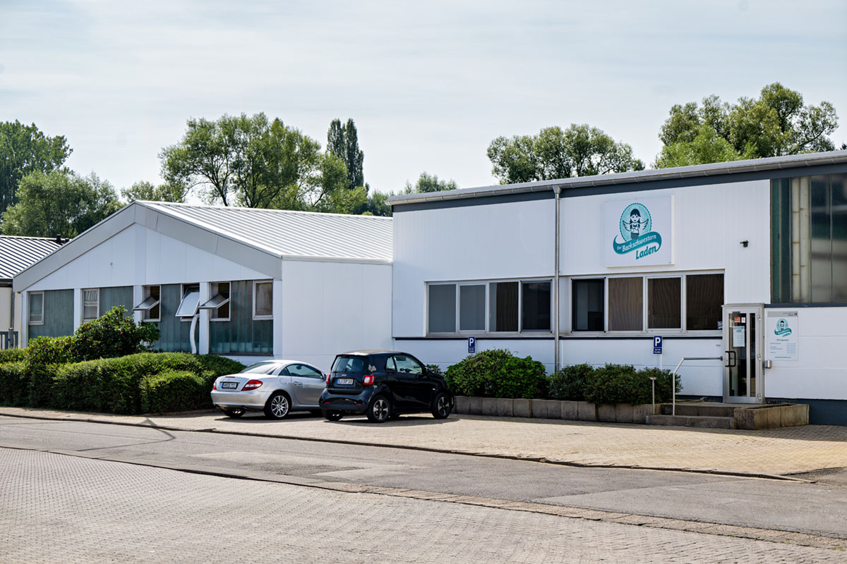 Modern daycare center building exterior with parking area and signage in Ladens, Germany